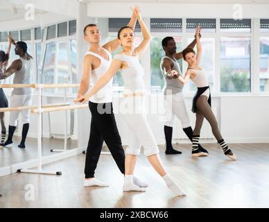 Young Asian woman practicing ballet moves with partner in dance studio Stock Photo