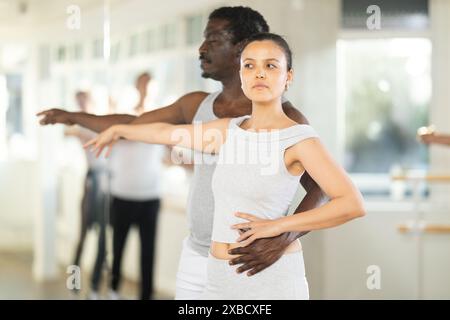 Asian female amateur ballet dancer mastering partnered dance in studio Stock Photo