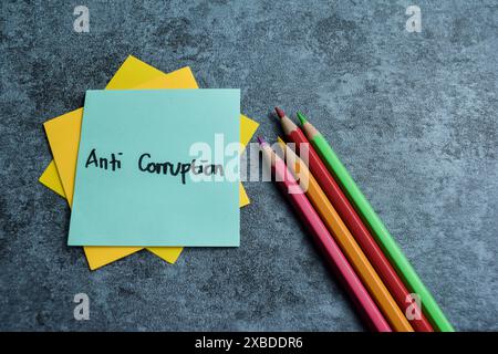 Concept of Anti Corruption write on sticky notes isolated on Wooden Table. Stock Photo