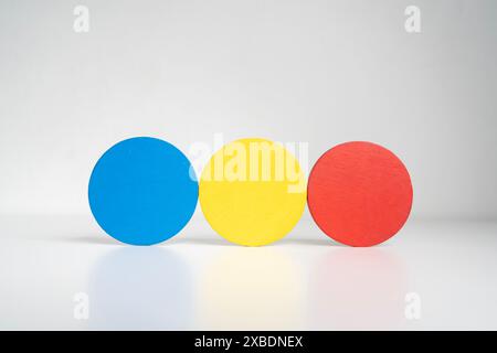 Three different colored balls are stacked on top of each other. The balls are blue, yellow, and red. Concept of playfulness and creativity, as the col Stock Photo