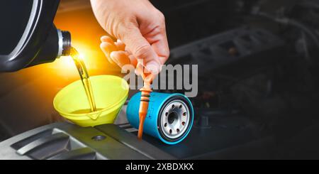 Car maintenance service , Pouring engine oil into a funnel with spare parts for engine maintenance , copy space on dark background for text , Car repa Stock Photo