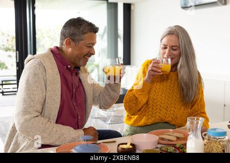 A biracial mature couple enjoying meal together at home, at home Stock Photo