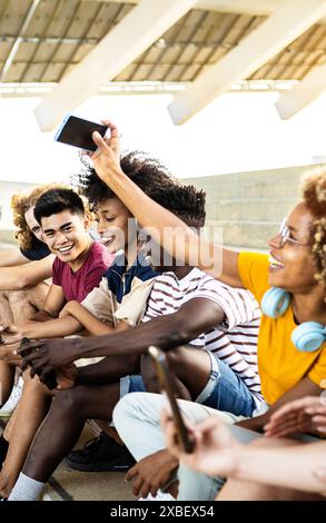 Multiracial group of teenager students using mobile phone outdoors Stock Photo