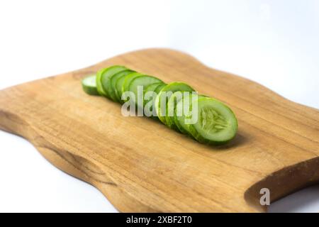cucumber slice on a wooden chopping board, isolated on white background Stock Photo