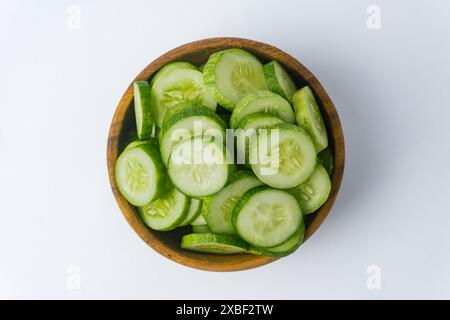 fresh juicy slice cucumber in a wooden bowl, isolated on white background Stock Photo