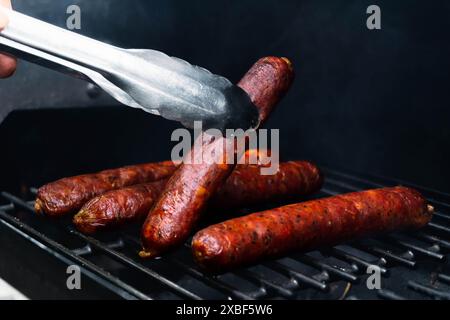 sausages with edible collagen casing are being cooked using the smoking method that produce red mahogany color Stock Photo