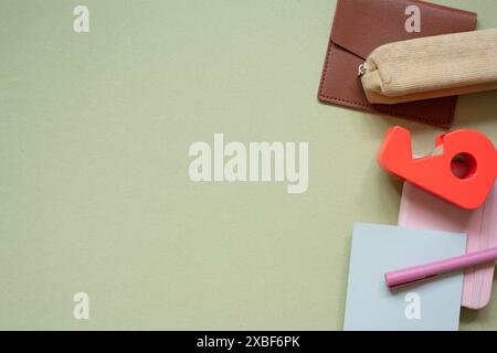Various office and school supply. pen, pencil case, card wallet, memo pad, notebook, tape dispenser on khaki desk background. top view Stock Photo
