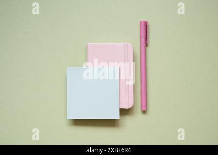 Pink diary notebook, memo pad, pen on khaki desk background. top view Stock Photo