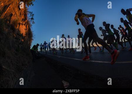 Ultra Distance Runner Marathon runners silhouetted morning dawn sunrise running up hill in ...