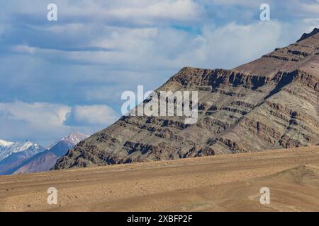 An abstract landscape of barren mountain ranges and snow clad mountains in Ladakh Stock Photo