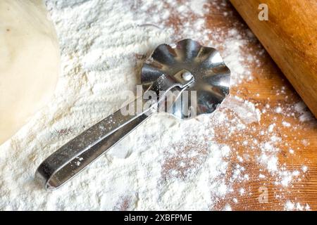 forms for squeezing the dough. dough on the table with dough tools. Stock Photo