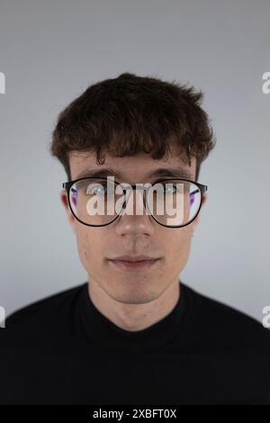 White background portrait in studio of young man wearing sight glasses Stock Photo
