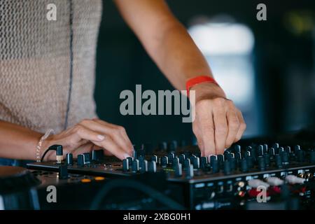 woman DJ Hands creating and regulating music on dj console mixer in a music festival Stock Photo