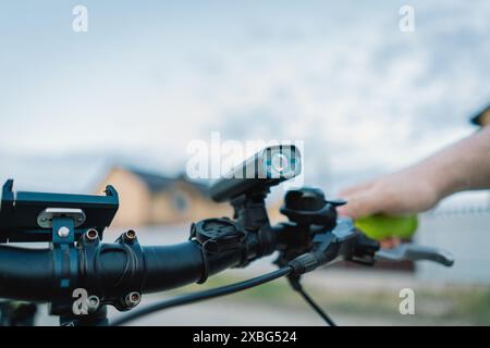 Closeup of a Black Mountain Bike Handlebars With Yellow Grips on a Dirt Road Stock Photo