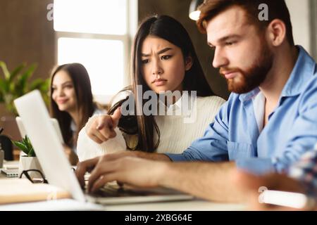 Studying together. College friends with laptop in library Stock Photo