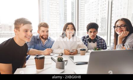 Skilled young programmers watching webinar on laptop computer Stock Photo