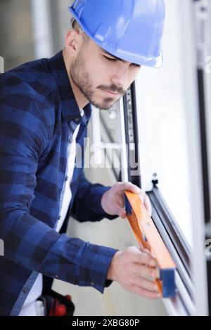 Builder using spirit level on construction site wall Stock Photo - Alamy