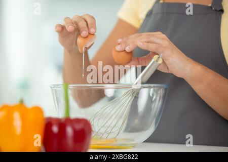 close-up of female hands breaking eggs Stock Photo