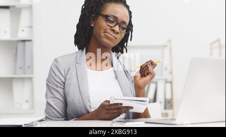 Thoughtful African American lady working on report Stock Photo