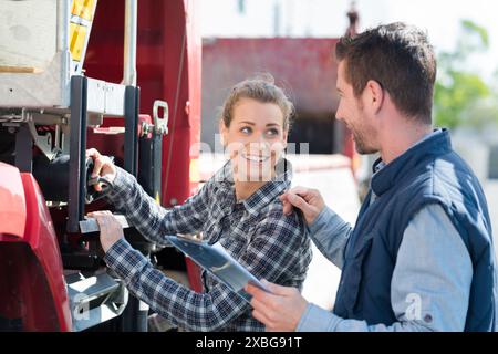 woman operating controls on side of lorry Stock Photo