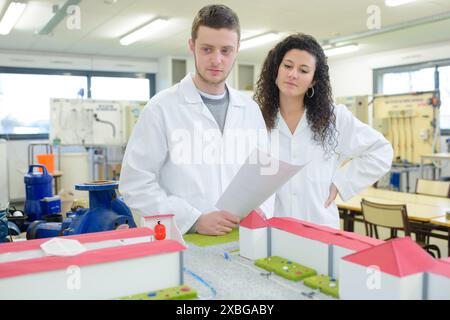 young engineers examining plans on construction site Stock Photo