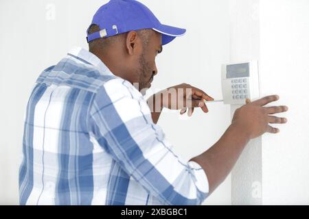 male technician installing security system using screwdriver Stock Photo