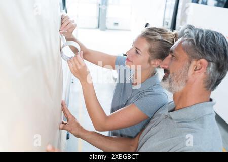 woman and man using masking tape in workshop Stock Photo