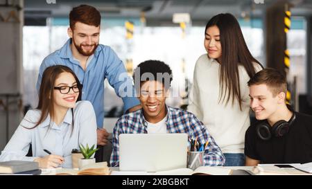 Group of People Sitting Around Table Looking at Laptop Stock Photo