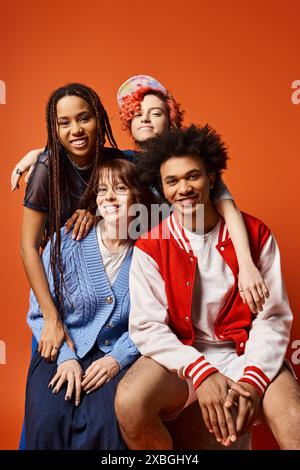 interracial young friends, including a nonbinary individual, sitting closely together in a studio setting in fashionable attire. Stock Photo