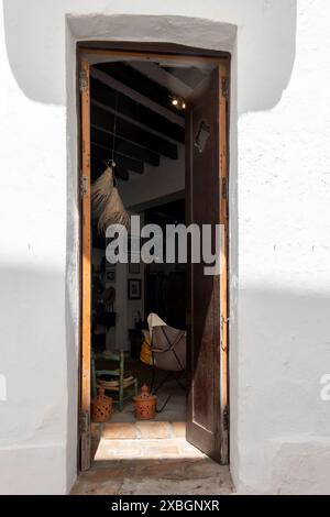 A tall, slender door set into the facade of a whitewashed house in Vejer de la Frontera, Cadiz, Andalusia, Spain. Stock Photo