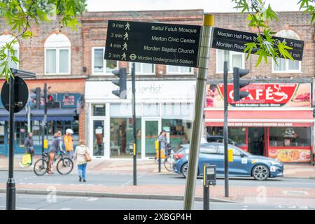 LONDON- JUNE 10, 2024: Pedestrian direction street sign for Baitul Futih Mosque, Merton Civic Centre, Morden Baptist Church and Morden Station Stock Photo