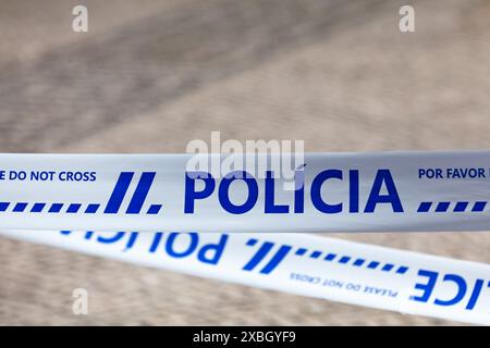 Police tape with written in it in Portuguese 'Polícia' meaning 'Police' in English. Stock Photo