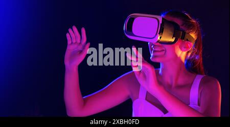 Excited Woman Using Virtual Reality Headset in Dusk Stock Photo
