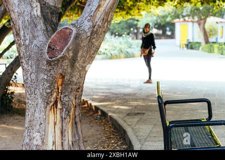 Park seat besides a tree trunk. Stock Photo