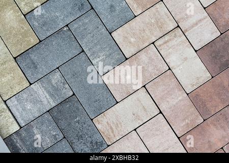 Multicolored paving slabs for road paving by mosaic on shop window. Construction Stock Photo