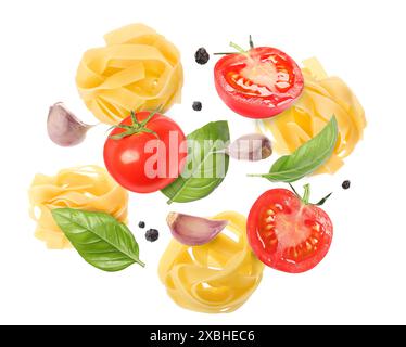 Raw pasta, tomatoes, garlic and basil in air on white background Stock Photo