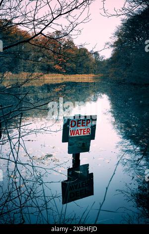 Deep water sign in a woodland lake. Stock Photo