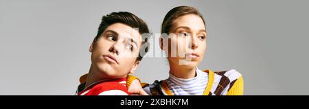 Attractive male and female students in casual attire standing next to each other in a college classroom. Stock Photo