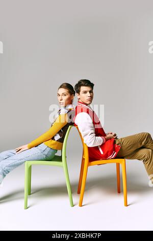 Stylish students lounge on a colorful chair in a college classroom. Stock Photo