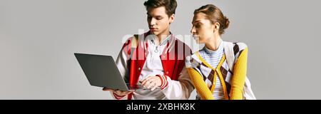Young male and female students engrossed in laptop in college classroom. Stock Photo