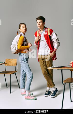 Two young individuals strike poses in a college classroom setting. Stock Photo