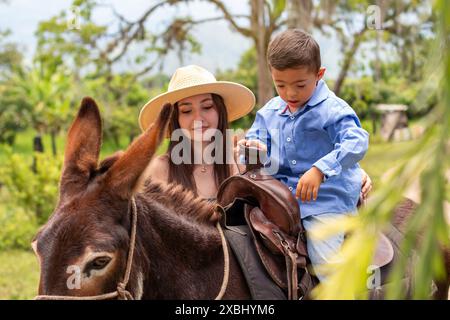 lifestyle: boy with down syndrome riding on his pet donkey with his sister Stock Photo