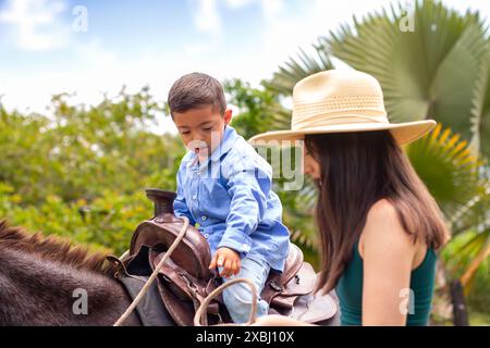 lifestyle: boy with down syndrome riding on his pet donkey with his family Stock Photo