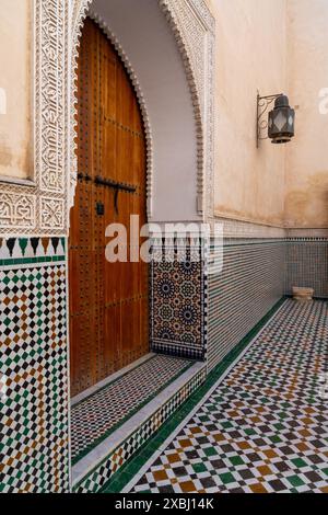 Meknes, Morocco - 5 March, 2024: architectural detail of a cedar door and Zeliij mosaic work in the inner courtyard of the Mausoleum of Moulay Isma'il Stock Photo