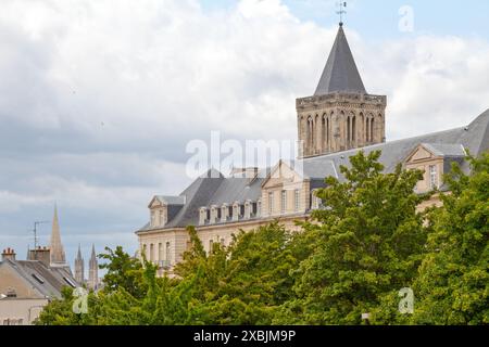 The Abbey of Sainte-Trinité (French: Abbaye de Sainte-Trinité), also known as Abbaye aux Dames with behind, the spire of St. Peter's churh (French: Ég Stock Photo