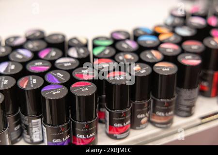 Osijek Croatia - 7 06 2024: close-up image of a shelf displaying a variety of colorful gel polish bottles. Each bottle is black with a clear glass sec Stock Photo