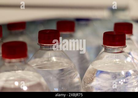 mineral water bottles with red cork caps are arranged in rows on the shelf Stock Photo