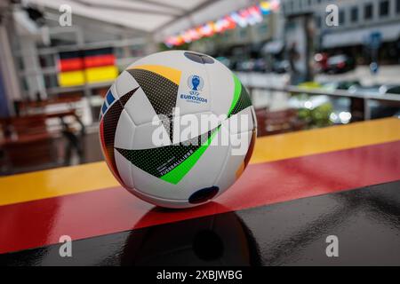 Wiesbaden, 11.06.2024, Symbolfoto Public Viewing der Fußball Europameisterschaft 2024, Fussballliebe Original Spielball zur UEFA EURO 2024 von Sportausrüster Adidas auf einem Tresen mit Deutschlandfahne. Wiesbaden Andechser Hessen Deutschland *** Wiesbaden, 11 06 2024, symbolic photo Public Viewing of the European Football Championship 2024, football love Original match ball for UEFA EURO 2024 from sports supplier Adidas on a counter with German flag Wiesbaden Andechser Hessen Germany Stock Photo