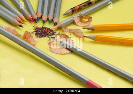 Sharpened pencil, eraser, compass and paper clips on a yellow background Stock Photo