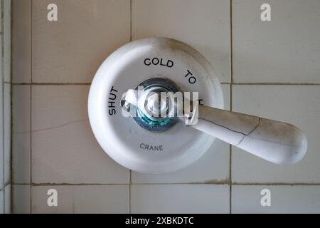 A vintage Crane porcelain single handle faucet valve for a shower/bath. Stock Photo